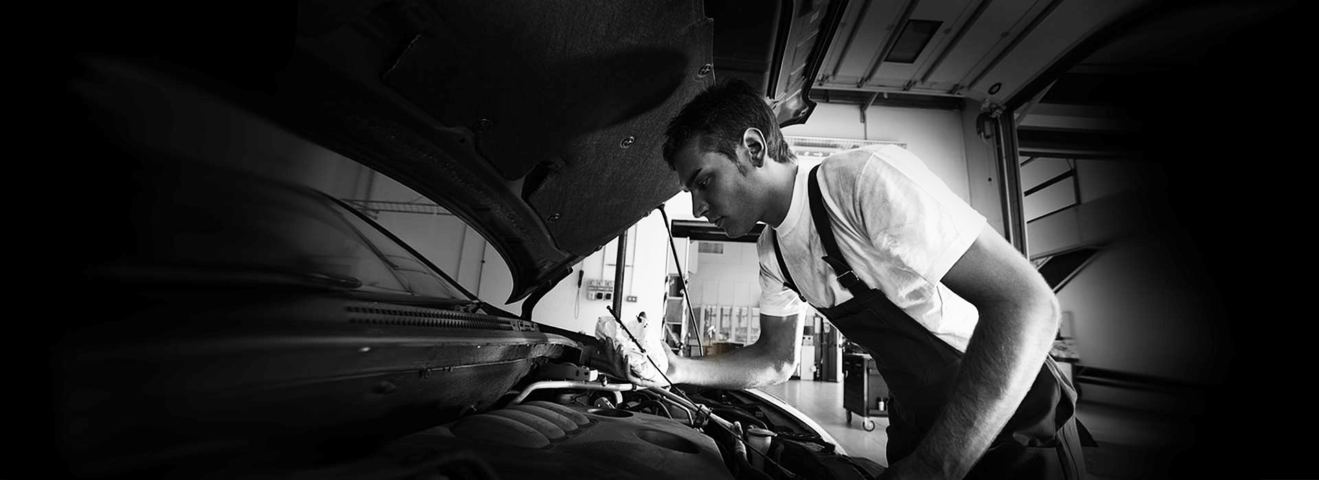 Mehanik pregleduje motor avtomobila v delavnici